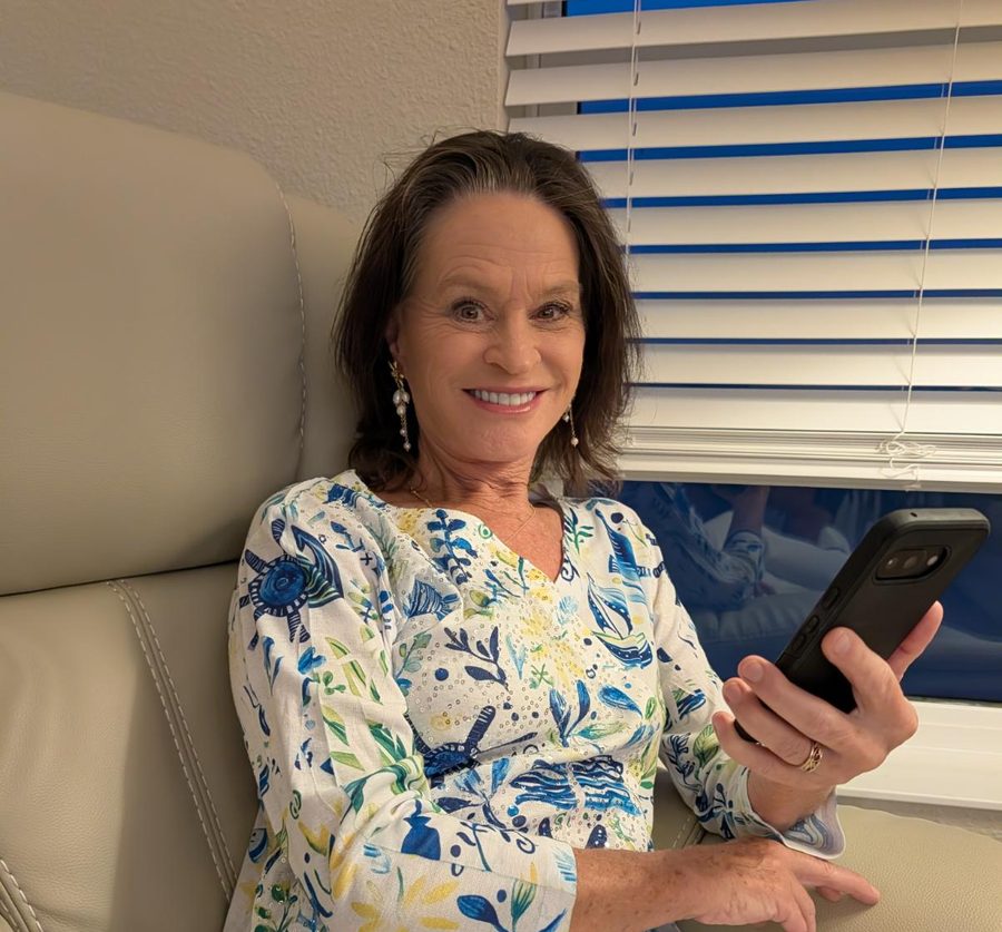 A grandmother smiling at a message from her grandchildren on her phone